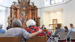 Menschen nehmen an einem Gottesdienst in einer Kirche teil