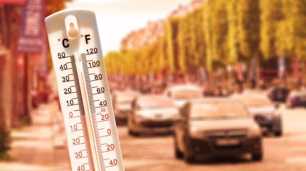 Thermometer im Vordergrund und Autos im Hintergrund.