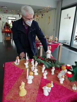 Malteser-Mitarbeiter richtet einen Adventstisch her.