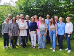 16 Teilnehmende des Grundkurses „Sterbende begleiten lernen…“ stehen nach dem Kursabschluss gemeinsam im Garten des Hospiz-Zentrums Volksdorf.