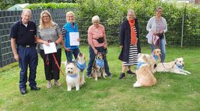 Besuchshundeteam mit den Hunden auf einer Wiese