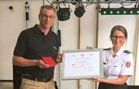 Der stellvertretende Diözesanleiter Matthias Geist (l.) nimmt die Verdiensturkunde und das Verdienstkreuz von Vizepräsidentin Clementine Perlitt entgegen (r.)