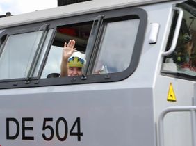 Lukas winkt aus dem Fenster einer Lokomotive