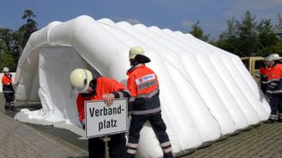 Helfer bauen ein Sanitätszelt auf