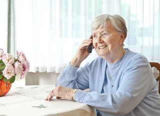 Seniorin telefoniert mit Malteser