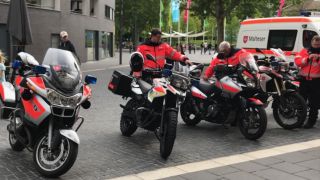 Die Motorräder der Motorradstaffel stehen neben einem Rettungswagen