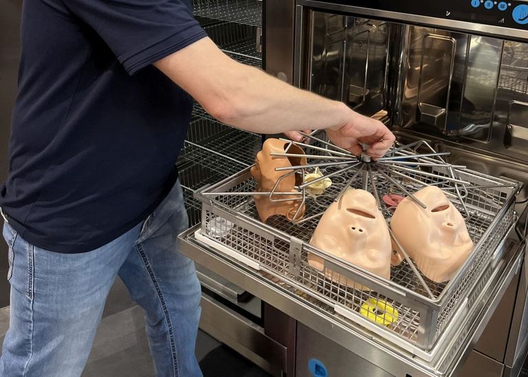 Ein Mann wäscht Gesichter aus Kunststoff