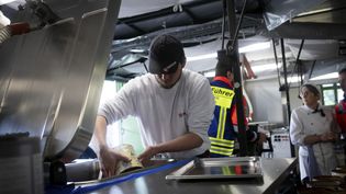 Helfer kochen an einer Feldküche