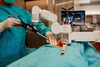 Robotergestützte Operation mit dem Maxor X, chirurgisch geführt und mit Anzeige des Eingriffsbereichs am Monitor.