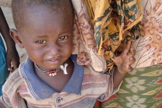 24_mothers and children wait to receive food June 2009 01
