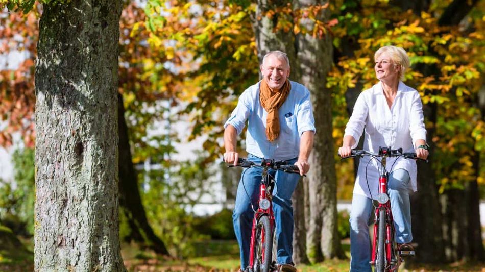 Es wird ein Seniorenpaar gezeigt, welche Fahrrad fahren.