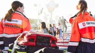 Zwei Helferinnen des Malteser Sanitätsdienstes laufen mit ihrer Einsatztasche zum Einsatz.