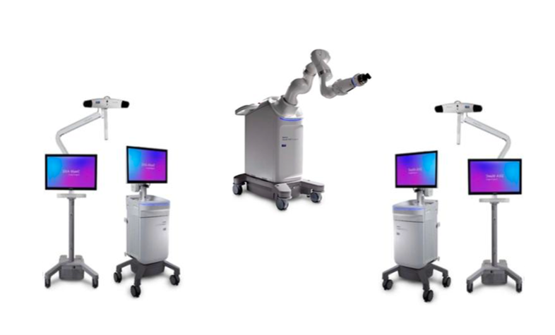 Mehrere medizinische Geräte mit Monitoren und Roboterarmen sind auf weißem Hintergrund angeordnet.