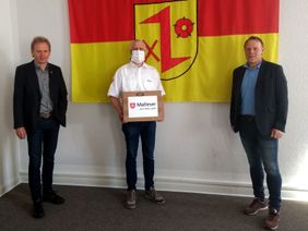 Klaus Möllers, stv. Stadtbeauftragter und Leiter der SEG Dinklage, übergibt 150 Behelfsmasken an Bürgermeister Frank Bittner (rechts) und Alfons Echtermann (links), Stadt Dinklage. Foto: Claudia Möllers