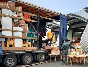 Mehrere Menschen beladen einen Lkw mit Hilfsgütern