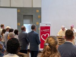 Die Besucher der Verabschiedung sitzen in der Messe, während Diözesanseelsorger Harald Niermann alle Anwesenden begrüßt