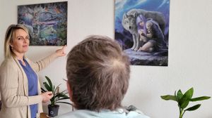 Zwei Frauen schauen gemeinsam auf ein Puzzlebild an der Wand