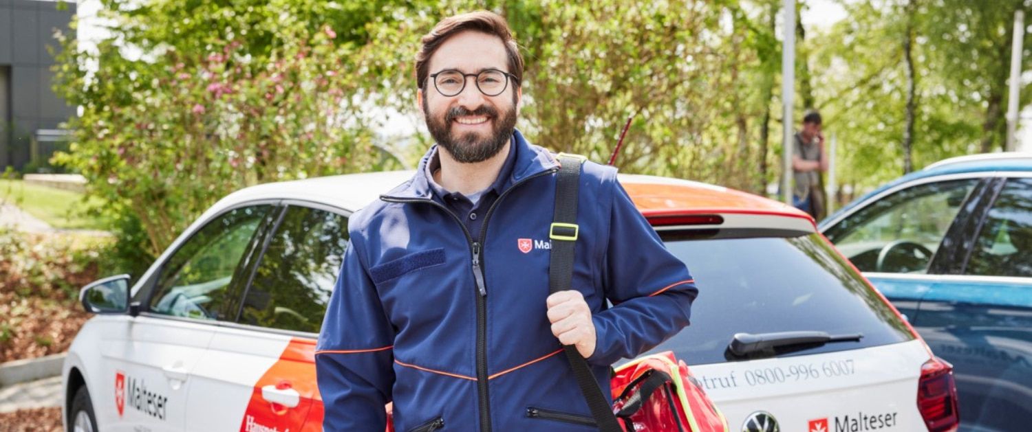 Malteser Hausnotruf Bereitschaftsdienstmitarbeiter lächelt in die Kamera.