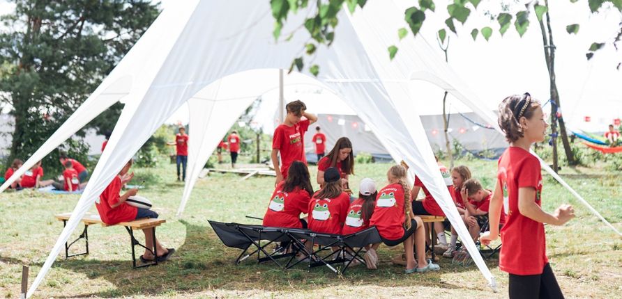 Gruppe von Kindern unter einem Zeltdach der Malteser