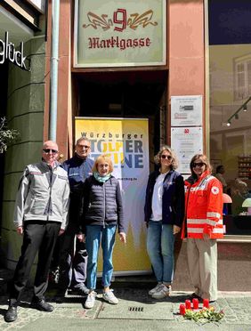 Gruppe Menschen vor Haustür mit Stolperstein