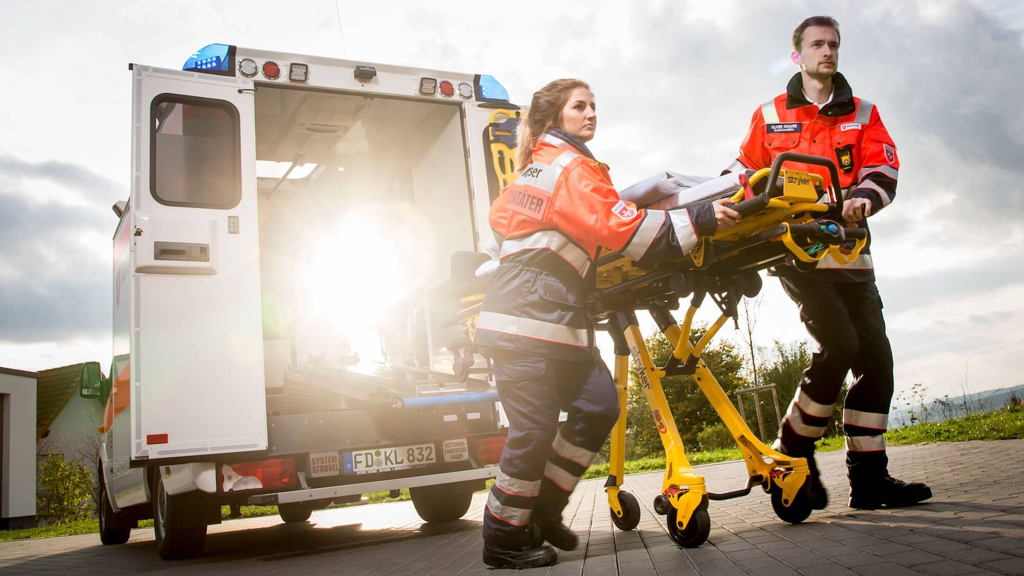 Zwei Rettungssanitäter schieben die Trage aus dem Retungswagen