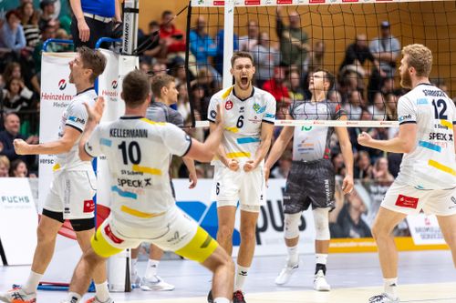 Spieler des SV Schwaig jubeln nach einem Punktgewinn, mitgereiste Fans und gegnerische Mannschaft im Hintergrund.