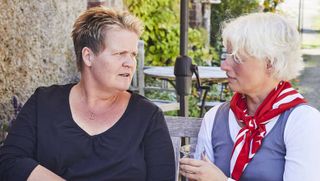 Eine Frau mit Malteser Halstuch spricht mit einer Frau.