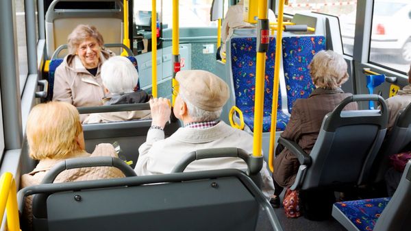 Eine Gruppe älterer Menschen in einem öffentlichen Bus.