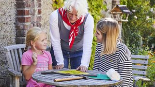 Ein Kind und zwei weitere Personen im Garten