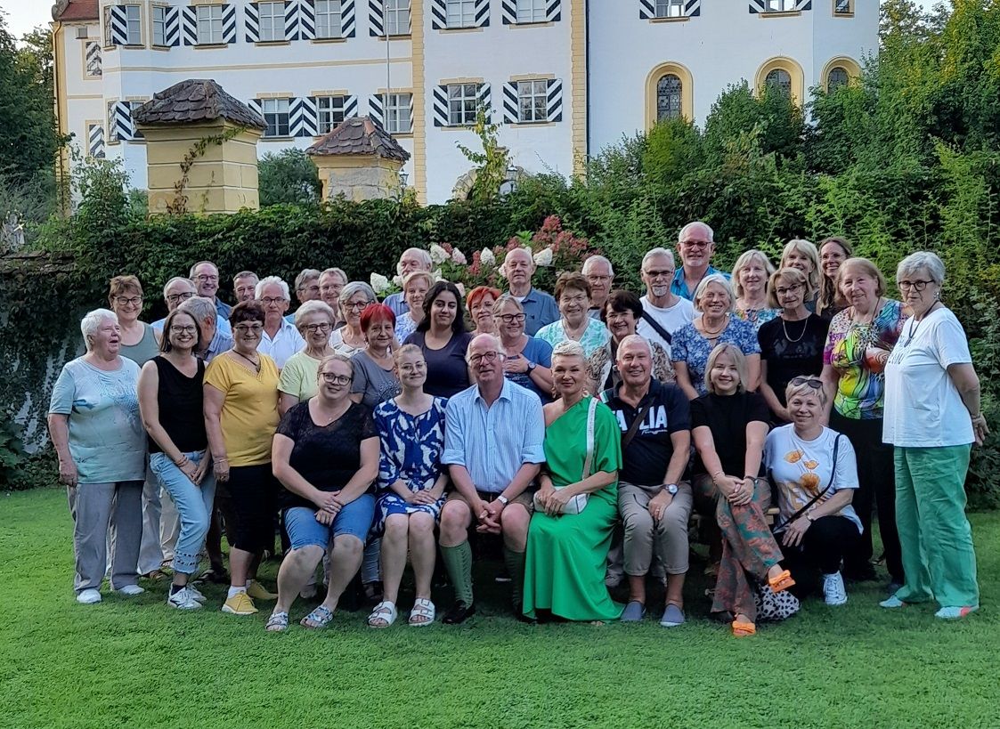 Ehrenamtliche vor einem Schloss