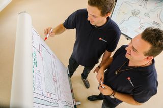 Zwei Männer schreiben auf ein Whiteboard