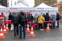 Bedürftige Menschen stehen vor den Pavillons der Malteser für die Essens- und Kleiderausgabe an.