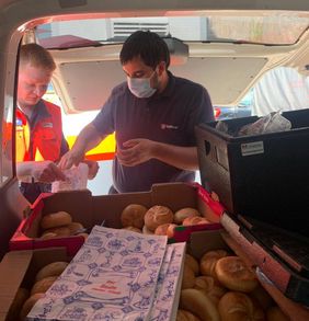 Malteser transportieren Brötchen und Verpflegung für Helfende und Betroffene.