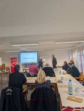 Zwei andere Teilnehmer üben Ehrungen im Rahmen eines kurzen Rollenspiels