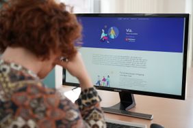 Eine Frau sitzt vor einem Computerbildschirm und liest. Foto: Lütke