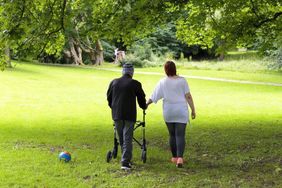 Hospizpatient mit Angehöriger gehen im Park spazieren