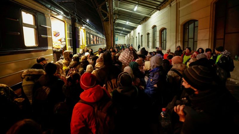 Menschen auf einem Bahnsteig bei Nacht 