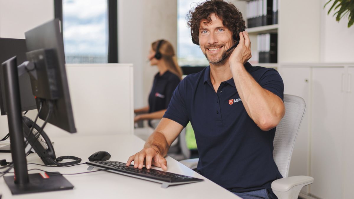 Malteser Mitarbeiter in der Hausnotrufzentrale nimmt einen Anruf an.