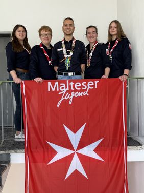 Gruppenfoto von den fünf gewählten Mitgliedern des Diözesanjugendführungskreises. Sie stehen oben an einer Treppe und vor ihnen ist das Malteser Jugend Banner gespannt.