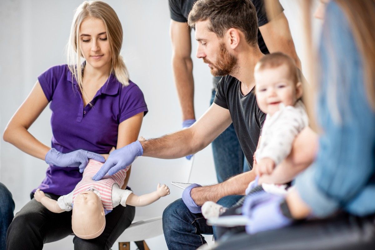 Menschen bei einem Erste-Hilfe-Kurs am Baby.