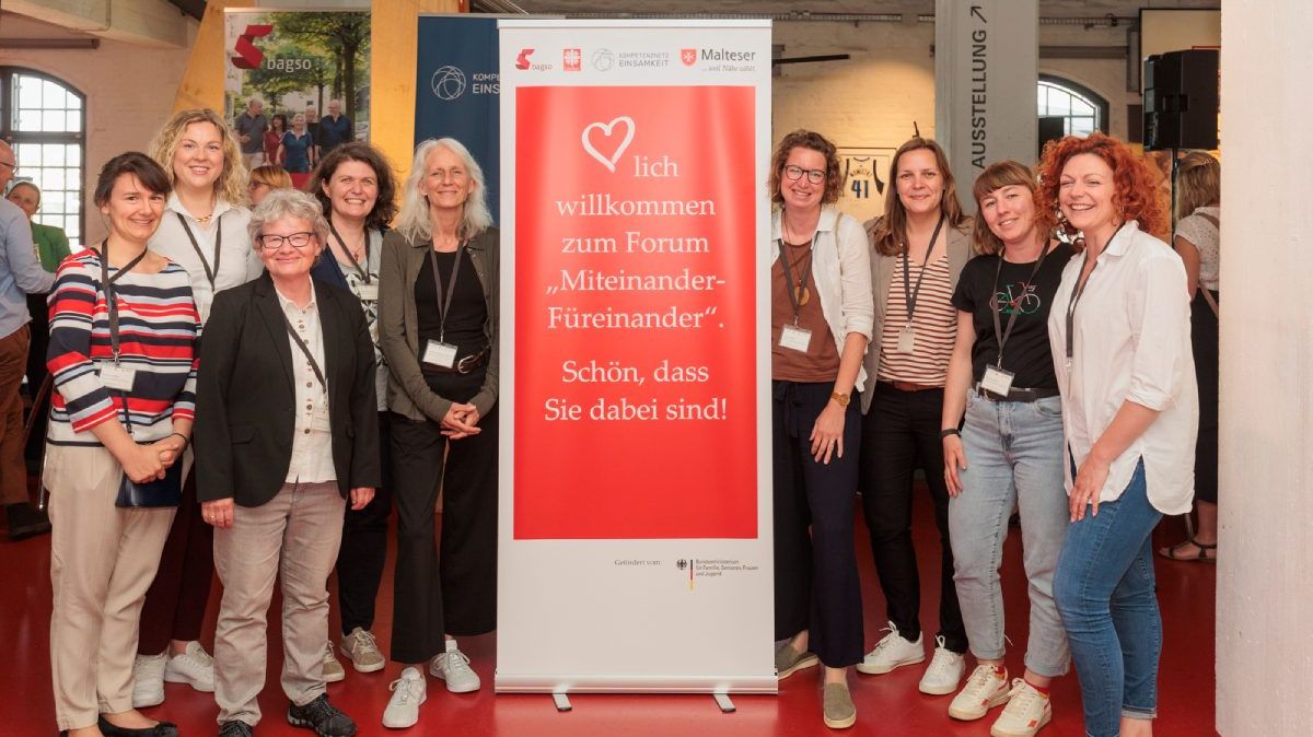 Eine Gruppe Frauen vor einem Banner.